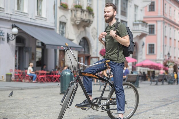 Handsome young man sitting on bicycle