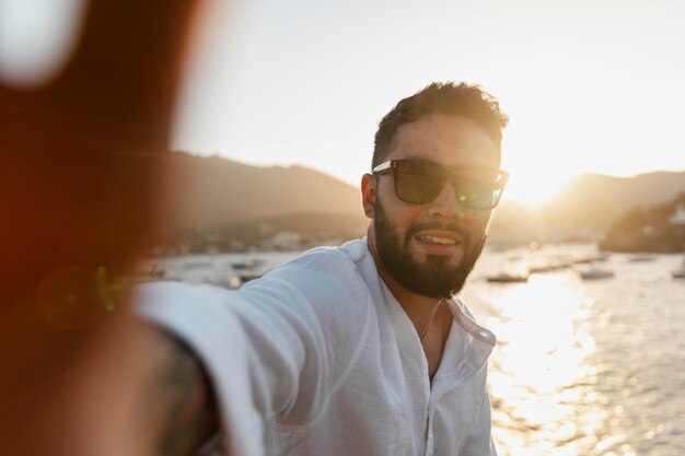 Handsome young man smiling by the lake