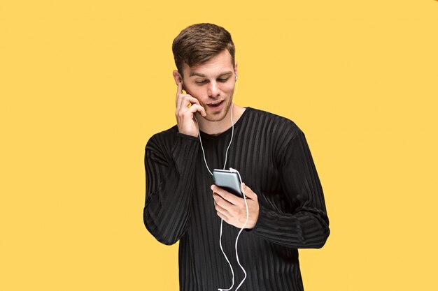 handsome young man standing and listening music.