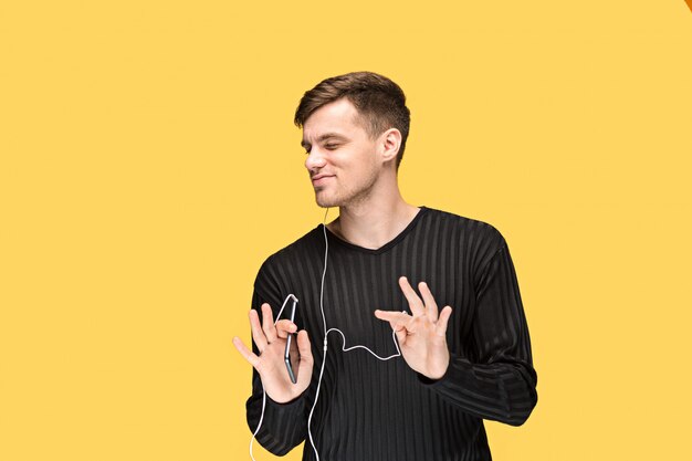 The handsome young man standing and listening music.