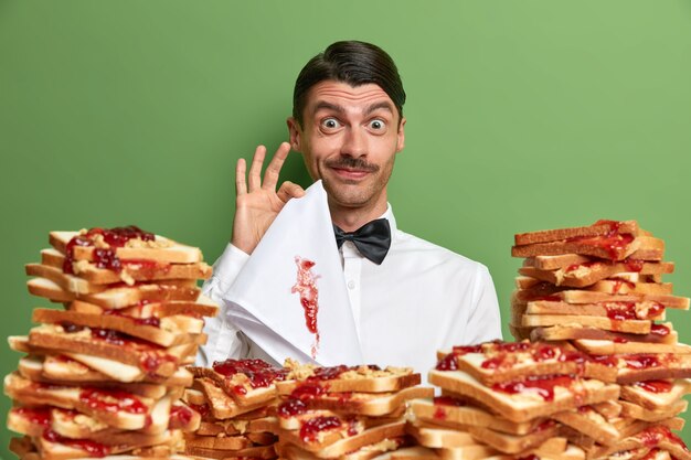 Handsome young man surrounded by peanut butter jellly sandwiches