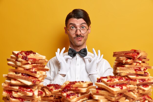 Handsome young man surrounded by peanut butter jellly sandwiches