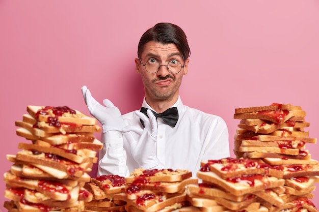 Handsome young man surrounded by peanut butter jellly sandwiches