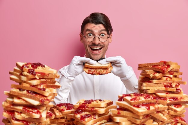 Handsome young man surrounded by peanut butter jellly sandwiches