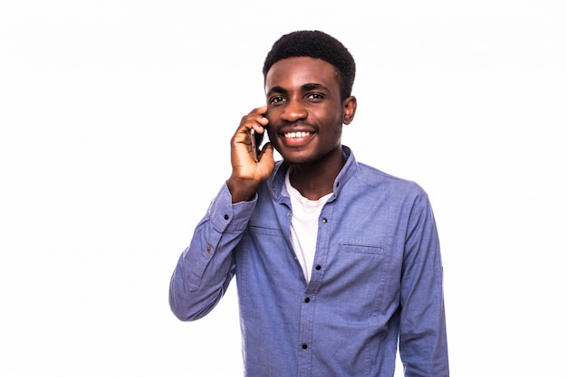 Handsome Young man talking on phone on white wall