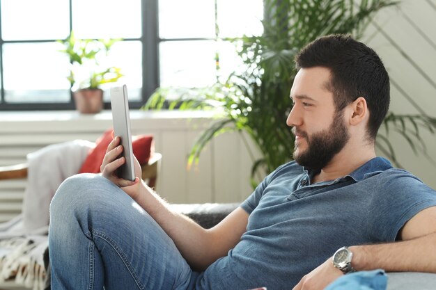 Handsome young man using digital tablet or ebook