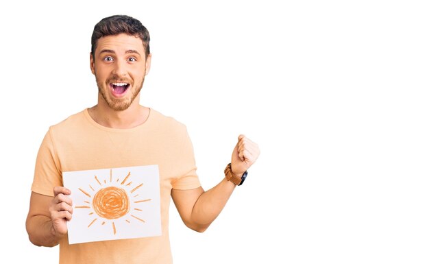 Handsome young man with bear holding sun draw screaming proud, celebrating victory and success very excited with raised arms