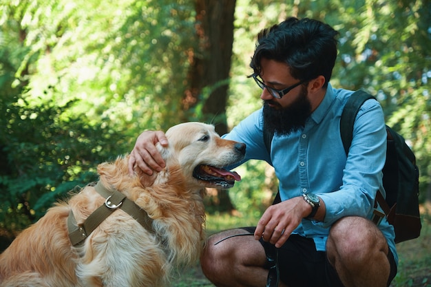 Handsome young man with golden retriver outdoors