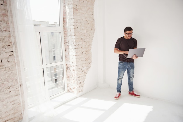 Handsome young man with laptop and check his timetable on white