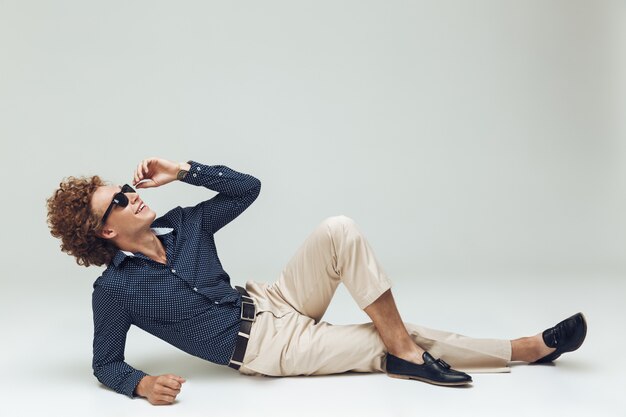 Handsome young retro man dressed in shirt lies on floor