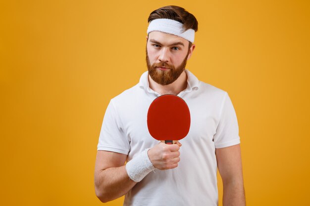 Free photo handsome young sportsman holding racket for table tennis
