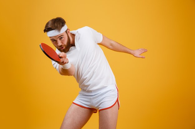 Handsome young sportsmand holding racket for table tennis.