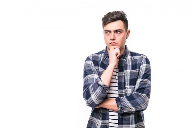 Handsome young thoughtful man isolated over white wall