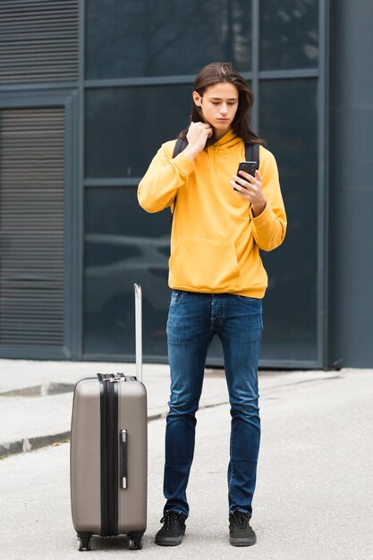 Handsome young traveler checking his phone