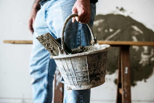 Handyman holding basket cement for construction