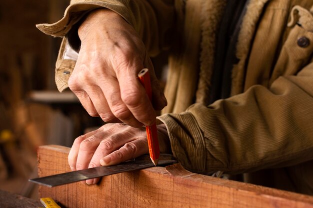 Free photo handyman making a pencil line on wood