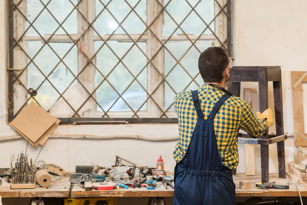 Foto gratuita tuttofare che fa mobili in legno in officina