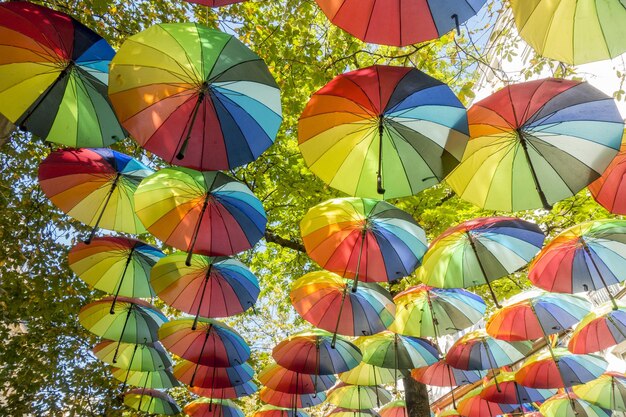 Висячие радужные зонтики в небе во время гей-прайда в районе Марэ в Париже, Франция.