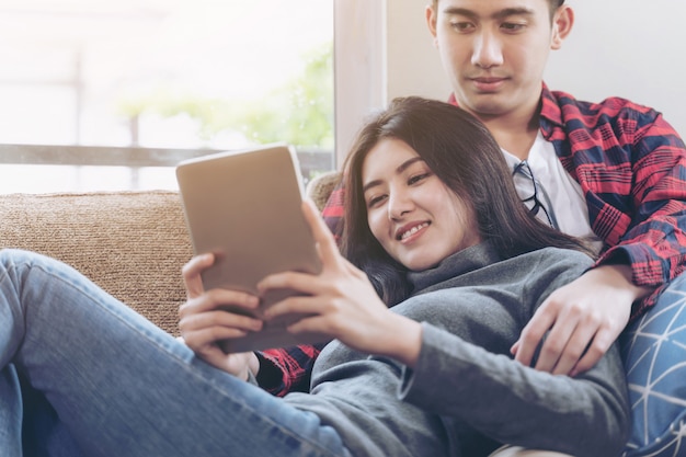Happily young couple use large smartphone at home