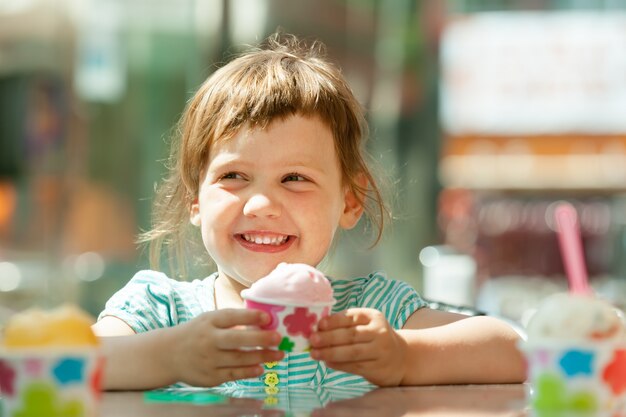 アイスクリームを食べる幸せな3歳の女