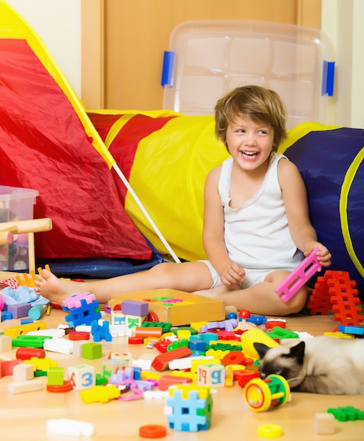 Un bambino felice di 4 anni che gioca con i giocattoli