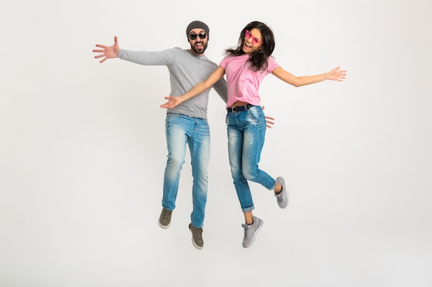 Happy active stylish man and woman jumping together isolated