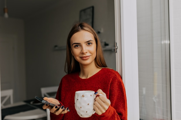 Free photo happy adorable lady with light-brown hair drinking coffee at home in warm day