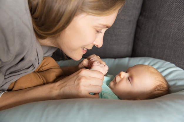 Felice adorabile nuova mamma a parlare con il suo bambino