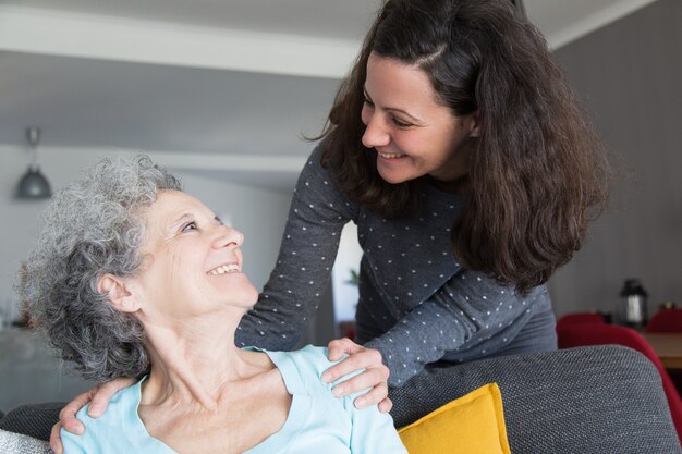 Happy adult daughter visiting elderly mother