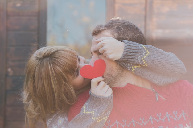 Free photo happy adult man and woman posing with red heart