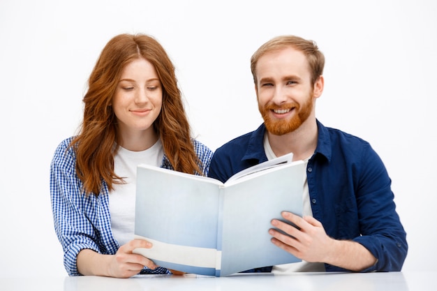 Happy adult redhead siblings look old photo album