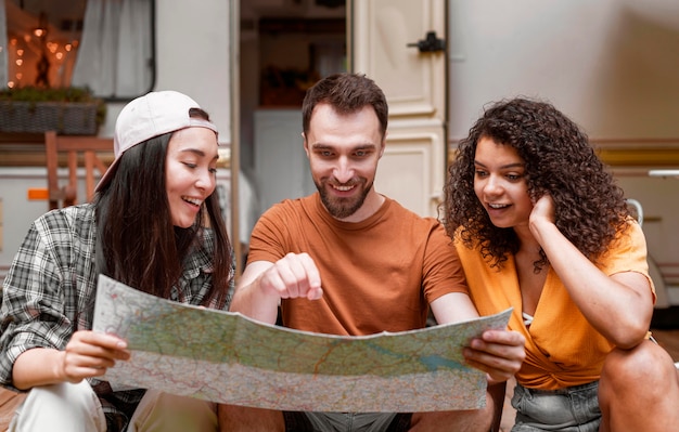 Free photo happy adventurous friends looking on a map