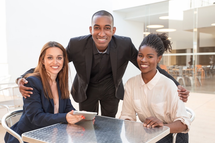 Free Photo happy african american businessman embracing female colleagues