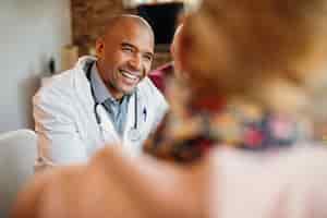 Free photo happy african american doctor in a home visit