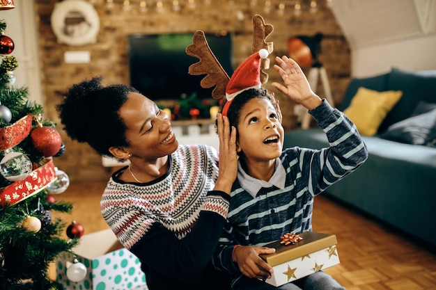 Felice madre e figlio afroamericani che si divertono il giorno di natale a casa