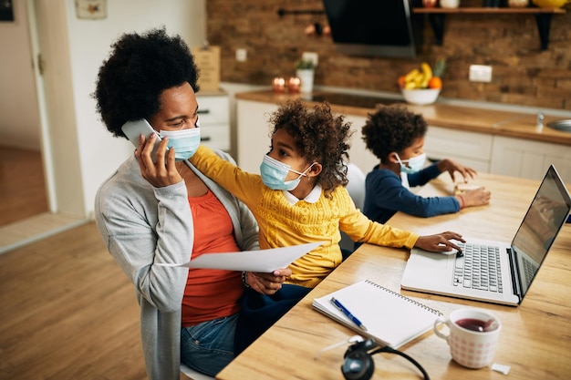 Happy African American mother working at home during coronavirus pandemic