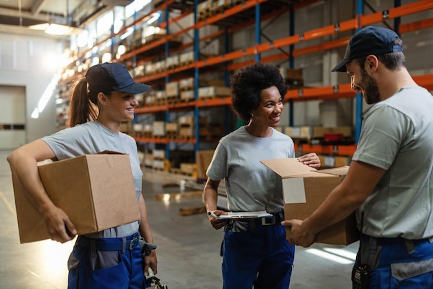 happy african american woman and her coworkers examining packages while working in distribution warehouse