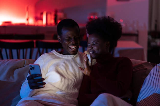 행복한 아프리카 커플 남녀는 집에서 스마트폰을 통해 친구나 가족과 화상 통화를 즐깁니다.