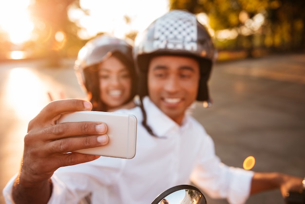 행복 한 아프리카 몇 현대 오토바이 야외와 스마트 폰 selfie를 타고 타기. 전화에 집중