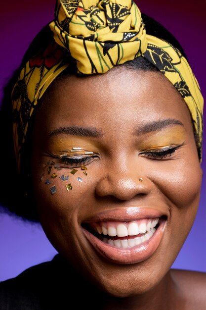 Happy african woman in leather vest with shiny confetti on her cheeks