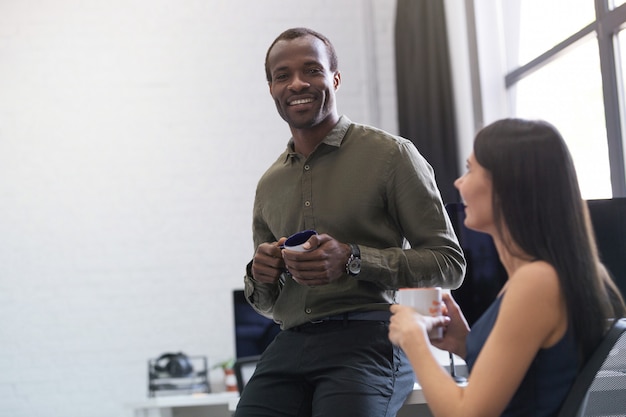 Happy afro american guy chatting with a female colleague