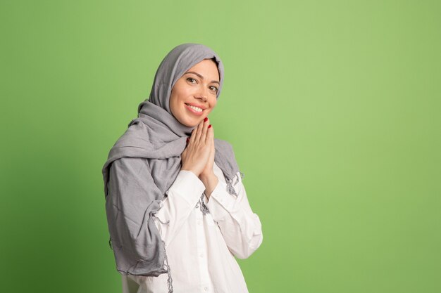 Hijab에서 행복 한 아랍 여자입니다. 녹색 스튜디오에서 포즈 웃는 소녀의 초상화.