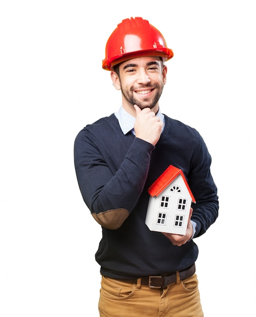 Happy architect touching his chin while holding his project