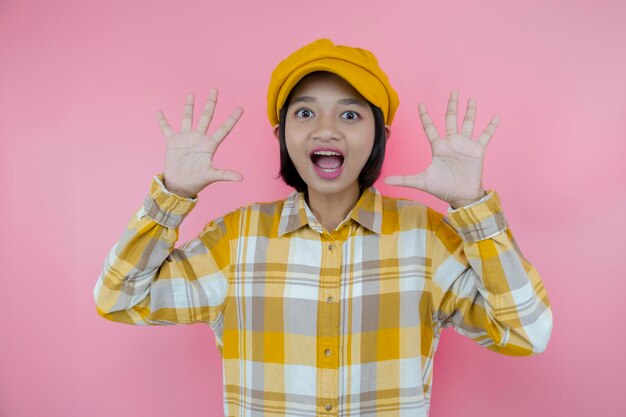 Happy asia young girl wear yellow shirt and yellow hat with pink background.