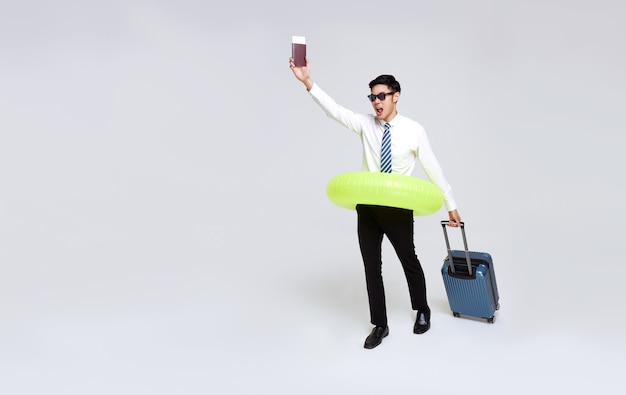 Happy Asian businessman with passport and luggage enjoying their summer vacation getaway.