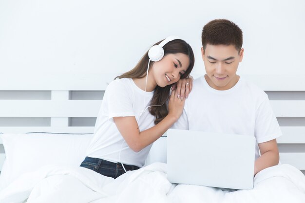 Happy Asian couple on the bed at home