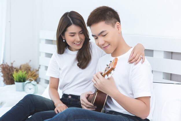 Happy Asian couple on the bed at home