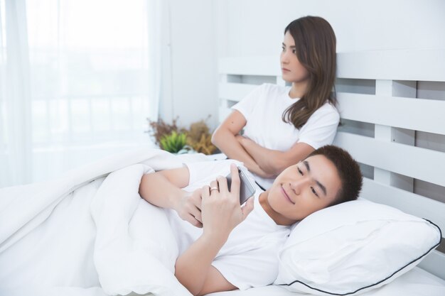 Happy Asian couple on the bed at home