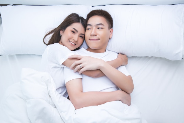 Happy Asian couple on the bed at home