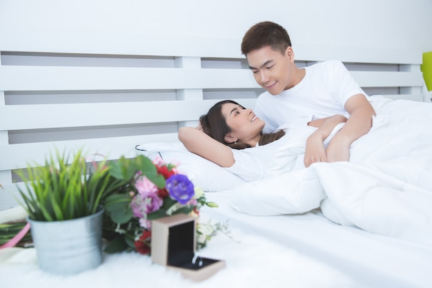 Happy asian couple on the bed at home